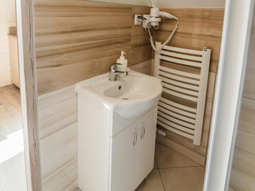 a bathroom with a white sink and a chair at Apartamenty na wzgórzu in Krościenko