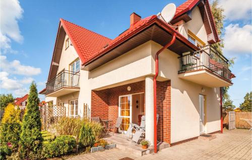 ein Haus mit rotem Dach in der Unterkunft Cozy Apartment In Rowy With Kitchen in Rowy