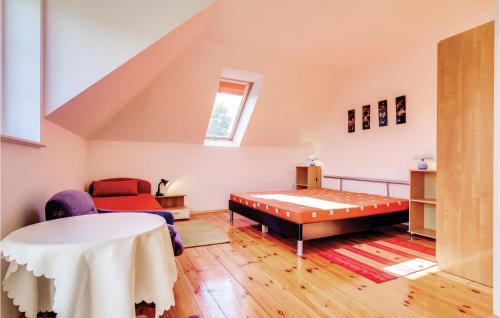 a attic room with a bed and a table at Cozy Apartment In Rowy With Kitchen in Rowy