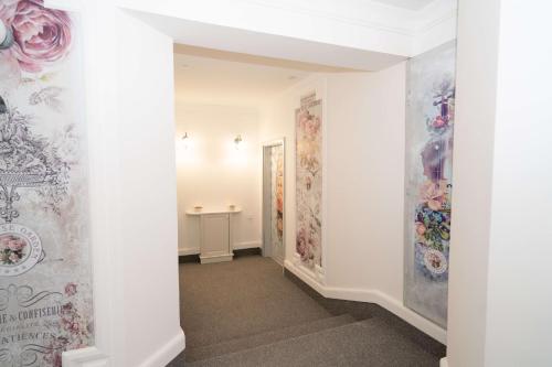 a hallway with white walls and paintings on the walls at Villa Rose Garden in Nyíregyháza