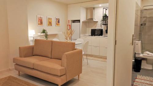 a living room with a chair and a kitchen at Naty Studio with Terrace in Vila Nova de Famalicão