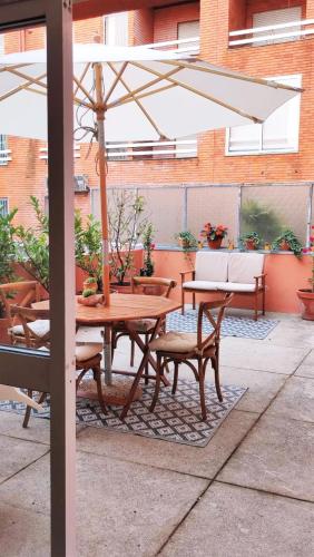a table and chairs under an umbrella on a patio at Naty Studio with Terrace in Vila Nova de Famalicão