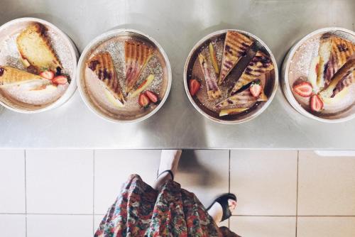 a woman standing in a kitchen with four pans of food at FORREST in Polanica-Zdrój
