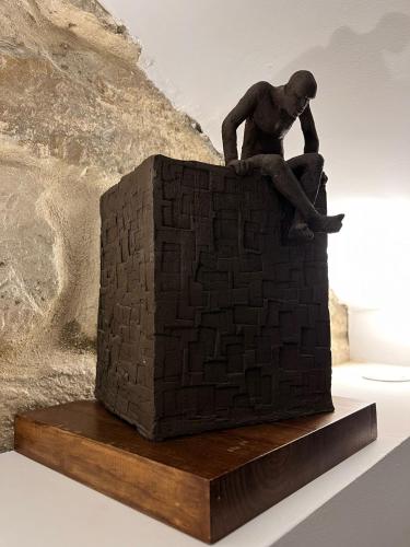 a statue of a man sitting on a brick wall at Hostal Casa de Luna y Sol in Úbeda