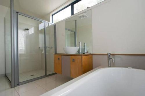 y baño con bañera, lavamanos y ducha. en Panoramic views from your stunning 'Treehouse', en Grindelwald