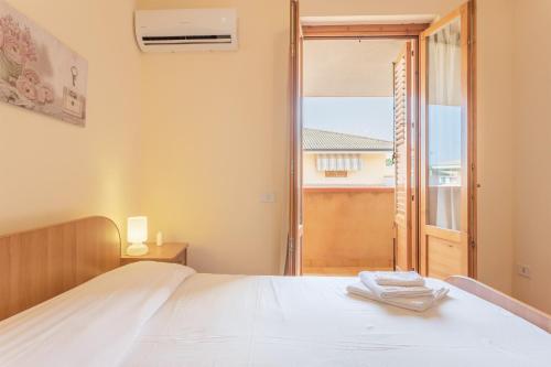 una camera con un letto bianco e una finestra di San Carlo - private beach a Palermo