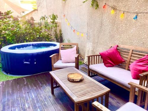 a patio with a hot tub and two chairs and a table at Magnifique VILLA avec jacuzzi au pied du STADE in Saint-Denis