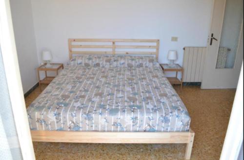 uma cama num quarto com duas mesas de cabeceira em Appartamento 6 em Ameglia