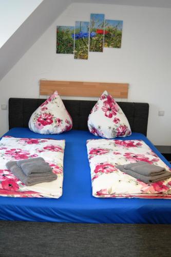 ein Bett mit zwei Kissen darüber in der Unterkunft Pension-Gästehaus Oberscheven Leipziger Neuseenland in Kitzscher