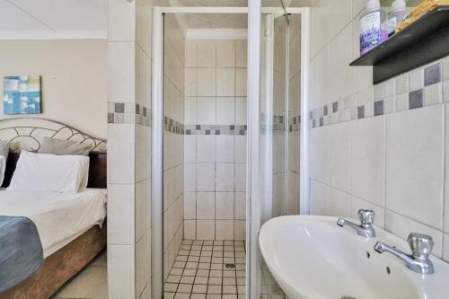 a bathroom with a tub and a sink and a bed at St Lucia Safari Lodge Holiday Home in St Lucia