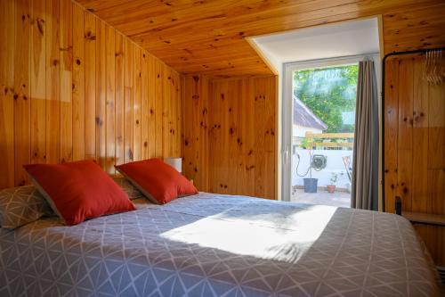 Un dormitorio con una cama con almohadas rojas y una ventana en Amplio apartamento independiente con terraza, en Brunete