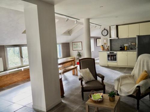 une cuisine et un salon avec une table et des chaises dans l'établissement Les grives aux loups, à Brive-la-Gaillarde