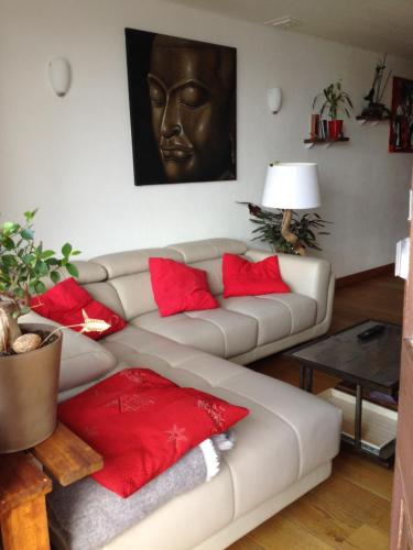 ein Wohnzimmer mit einem Sofa und roten Kissen in der Unterkunft Appartement T3 pour 6 personnes in Tignes