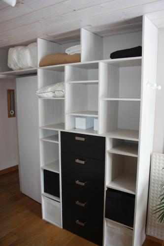 a closet with white and black shelves at Appartement T3 pour 6 personnes in Tignes