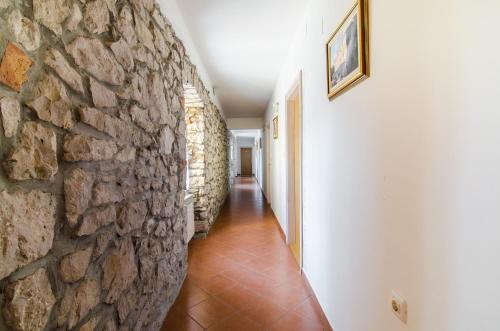 a hallway with a stone wall and a tile floor at Villa Calussovo in Ripenda Kras