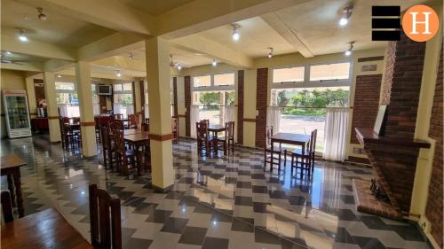 restauracja ze stołami i krzesłami oraz podłogą wyłożoną szachownicą w obiekcie El Hotelito w mieście San José