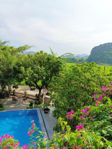 a swimming pool in a garden with flowers at Tam Coc Sunshine Homestay in Ninh Binh
