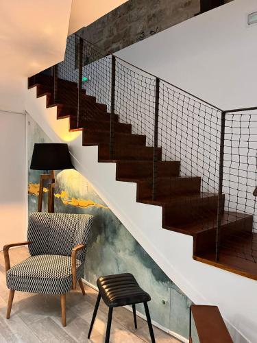 a living room with a staircase and a chair at Hostal Casa de Luna y Sol in Úbeda