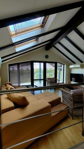 a bedroom with a large bed in a room with windows at Golf House Paradise in Topola