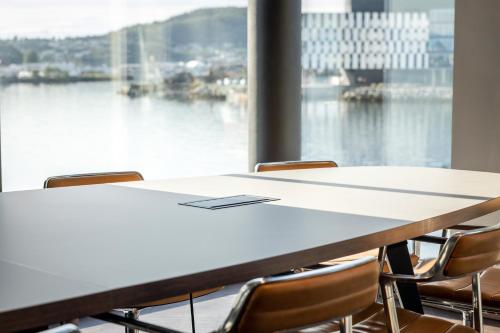 a conference room with a table and chairs and a large window at Quality Hotel Harstad in Harstad