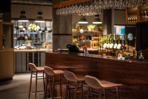a bar with chairs and a counter in a restaurant at Quality Hotel Harstad in Harstad