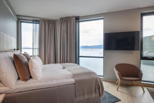 a bedroom with a large bed and a large window at Quality Hotel Harstad in Harstad