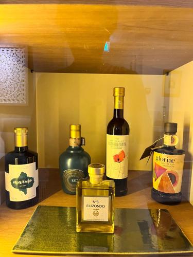 a shelf with four bottles of oils on a table at Hostal Casa de Luna y Sol in Úbeda