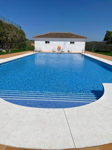 una gran piscina azul con un edificio en el fondo en Small Oasis in Costa del sol, en Manilva