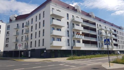 un edificio blanco con balcones en el lateral de una calle en Malta Delux Apartment, free parking, self check-in 24h en Poznan