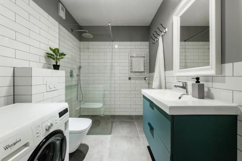 a bathroom with a washing machine and a sink at Apartament Plac Litewski Premium No. 7 in Lublin