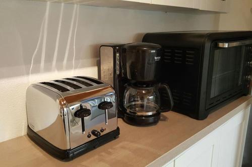 a toaster and a microwave on a kitchen counter at Le Chai de l'Océan - Studio in Soulac-sur-Mer