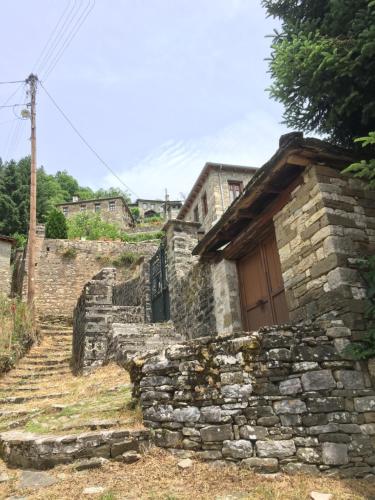 an old stone house with a door and stairs at KATIKIA ZAGORI in Vitsa