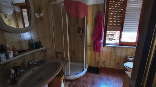 W łazience znajduje się prysznic, umywalka i wanna. w obiekcie Casa vacanze Isola Rossa w mieście Isola Rossa