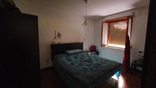 sypialnia z łóżkiem i oknem w obiekcie Casa vacanze Isola Rossa w mieście Isola Rossa
