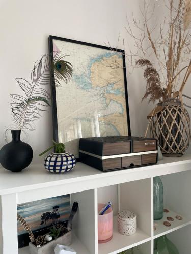 une étagère blanche avec une carte et des livres dans l'établissement Appartement Le bonheur de vivre, à Saint-Coulomb