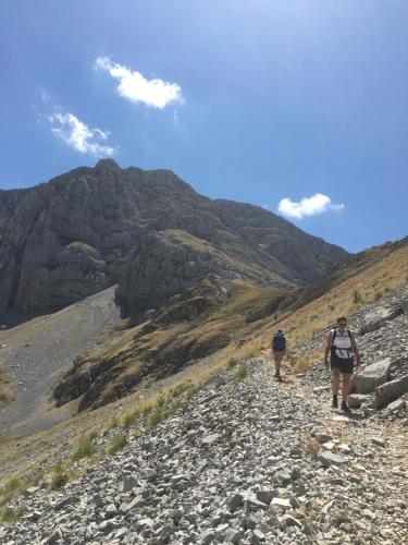 two people walking on a rocky mountain trail at KATIKIA ZAGORI in Vitsa