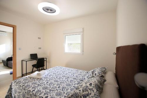 1 dormitorio con cama, escritorio y ventana en Apartamentos Amanecer Centro en Murcia