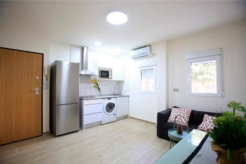 a kitchen with a refrigerator and a living room at Apartamentos Amanecer Centro in Murcia