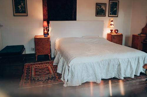 um quarto com uma cama branca e duas mesas de cabeceira em Private apartment in historic castle from 1608 with tenniscourt em Zeitlofs