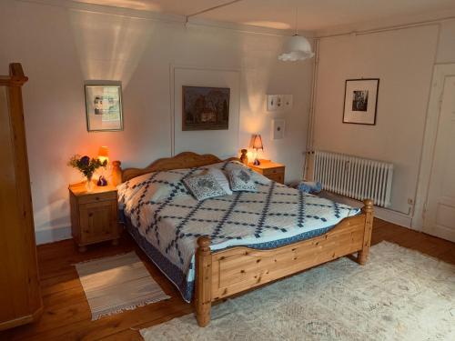 1 dormitorio con 1 cama de madera y 2 mesitas de noche en Private apartment in historic castle from 1608 with tenniscourt, en Zeitlofs