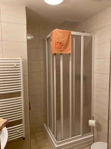 una ducha con una toalla naranja encima en Penzion Ovčárna, en Červená Voda