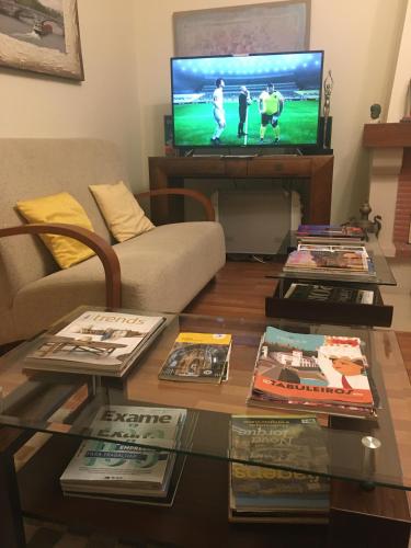 a living room with a coffee table and a tv at Alameda Residence in Tomar