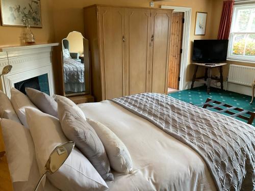 a bedroom with a bed with white sheets and pillows at The Jolly Farmer in Bramley