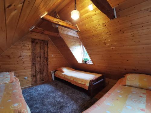 um quarto com duas camas num chalé de madeira em Wspaniały Zakątek em Sędziszowa