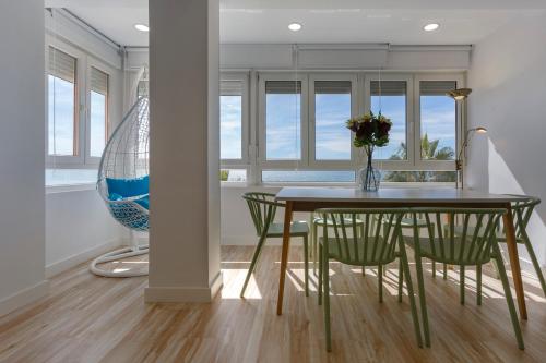 a dining room table and chairs with a vase of flowers at ACQUARELA Family Home free parking by Cadiz4Rentals in Cádiz