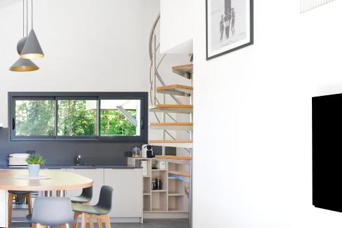 une cuisine et une salle à manger avec une table et des chaises dans l'établissement Maison Aranea, à Ascain