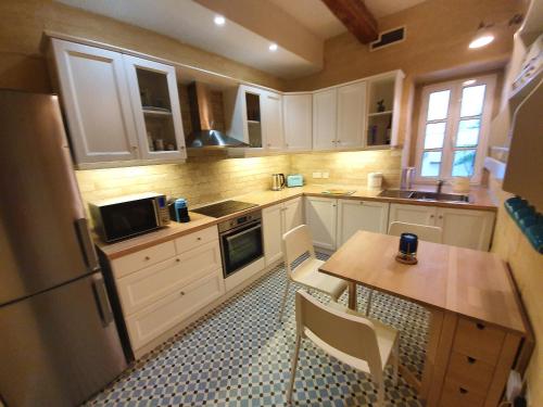 a kitchen with white cabinets and a table with chairs at Seven in Sliema