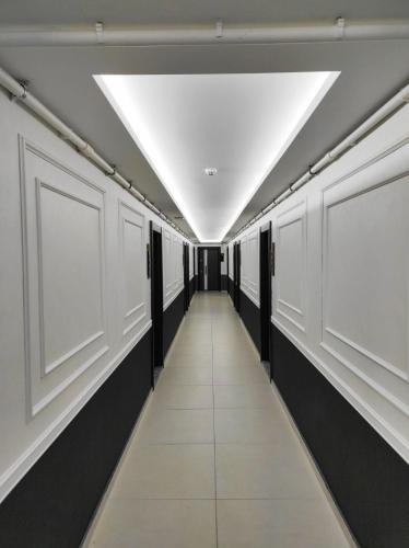 a hallway with white and black walls and a ceiling at Comfort Center Suit Hotel in Edirne