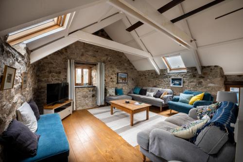 ein Wohnzimmer mit einer Steinmauer in der Unterkunft Stunning Converted Granary in Heart of St Davids in St. Davids