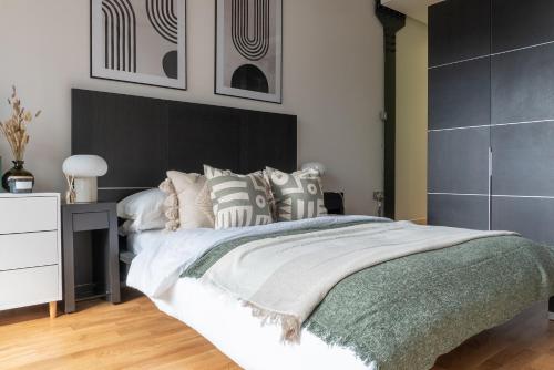 um quarto com uma cama grande e uma cabeceira preta em The Works - Central Manchester Apartment - 2 Parking Spaces em Manchester